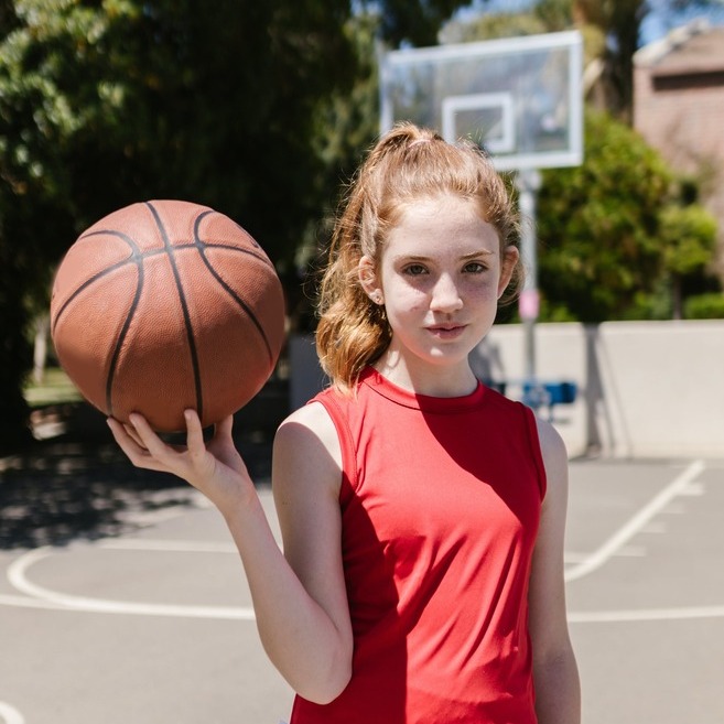 Kind van 12 met basketbal buiten