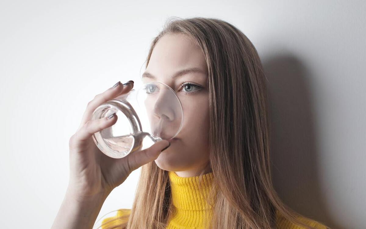 een vrouw die een glas water drinkt