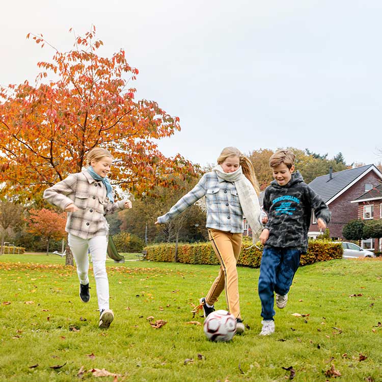 Kinderen voetballen op een veldje in de wijk