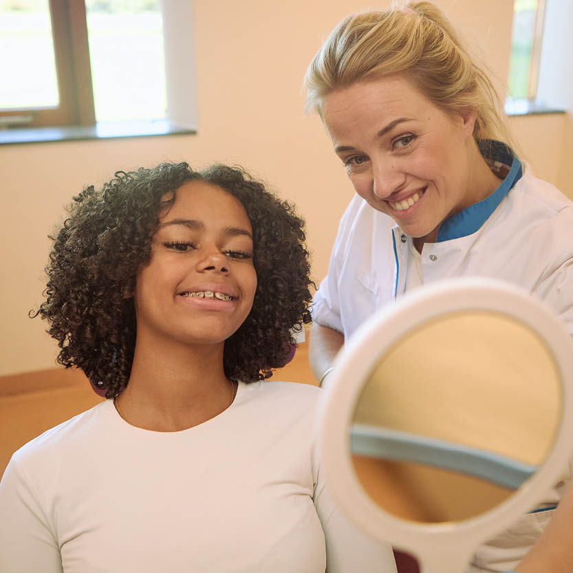 Meisje in de stoel bij orthodontist