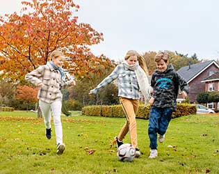 Jongeren voetballen op een veldje